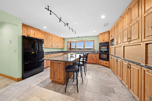 kitchen featuring recessed lighting, black appliances, a breakfast bar area, visible vents, and a kitchen island