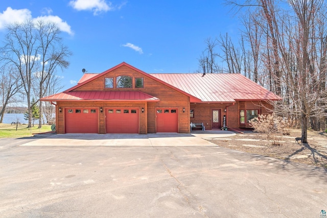 view of front of house with a garage, driveway, and a water view