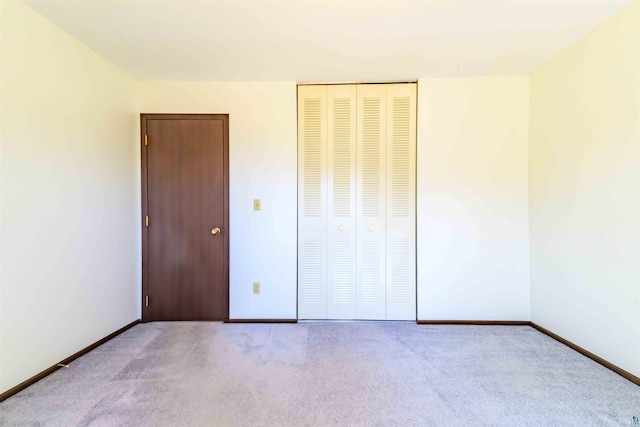 unfurnished bedroom with carpet floors, baseboards, and a closet