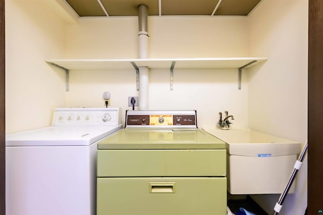 laundry area featuring washing machine and clothes dryer, laundry area, and a sink