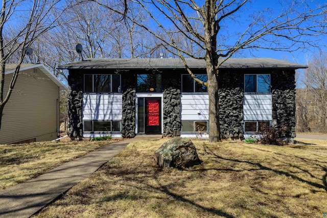 view of front of home featuring roof with shingles and a front lawn