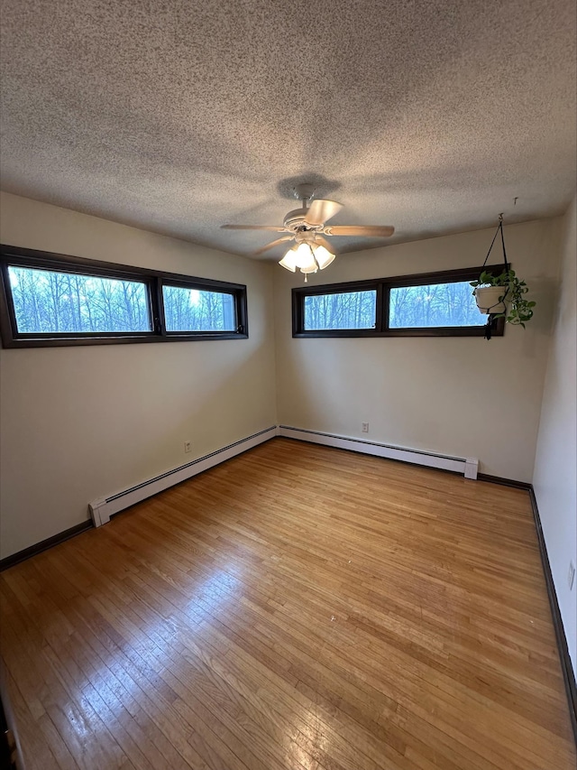 3824 Rehbein Rd, Duluth, MN 55803 - unfurnished room with ceiling fan, a textured ceiling, a baseboard radiator, a baseboard heating unit, and hardwood / wood-style floors