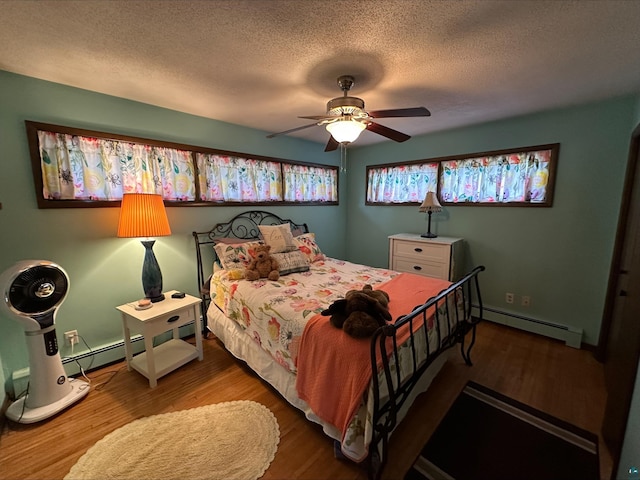 3824 Rehbein Rd, Duluth, MN 55803 - bedroom with wood finished floors, a textured ceiling, ceiling fan, and a baseboard heating unit