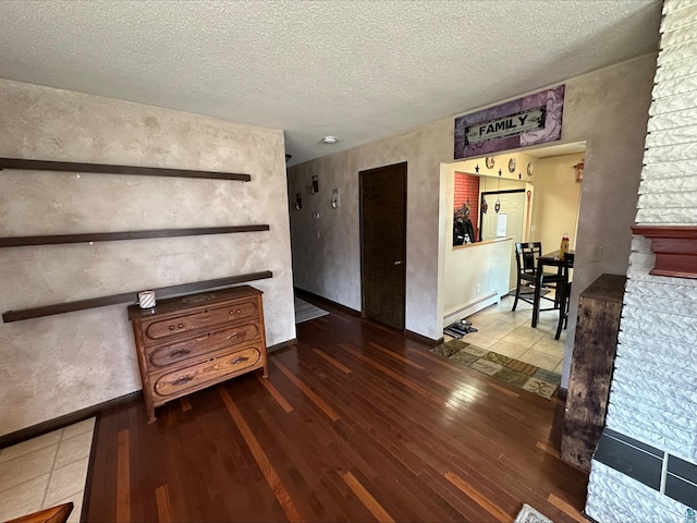 3824 Rehbein Rd, Duluth, MN 55803 - interior space featuring a textured ceiling, a baseboard radiator, baseboards, and wood finished floors