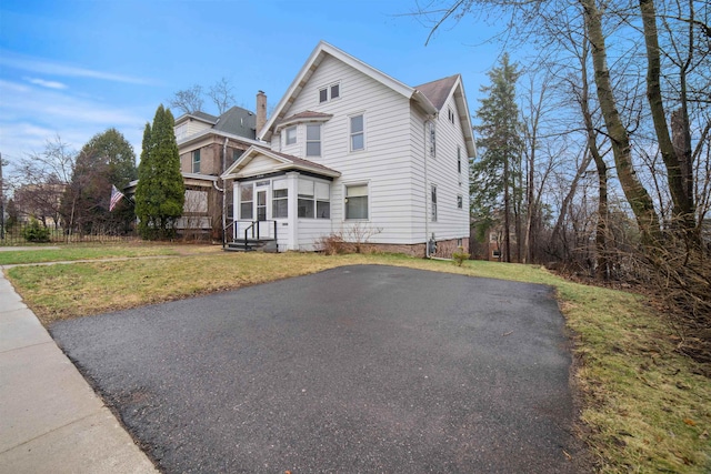 view of front of home featuring a sunroom and a front lawn