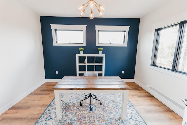 office featuring baseboards, a chandelier, plenty of natural light, and light wood-style floors