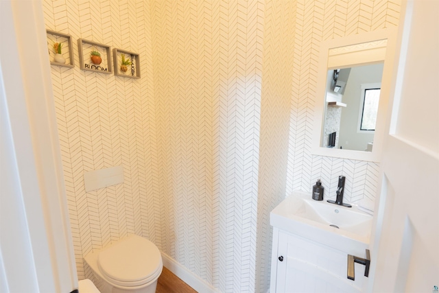 half bath with vanity, toilet, and tile walls