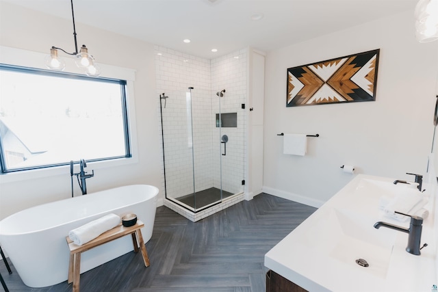 bathroom with recessed lighting, a freestanding bath, a shower stall, and vanity