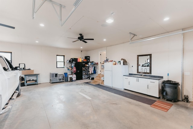 garage with a sink, freestanding refrigerator, and recessed lighting