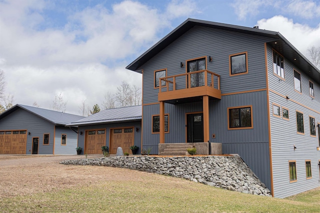 contemporary home with driveway, a front lawn, a balcony, and a garage