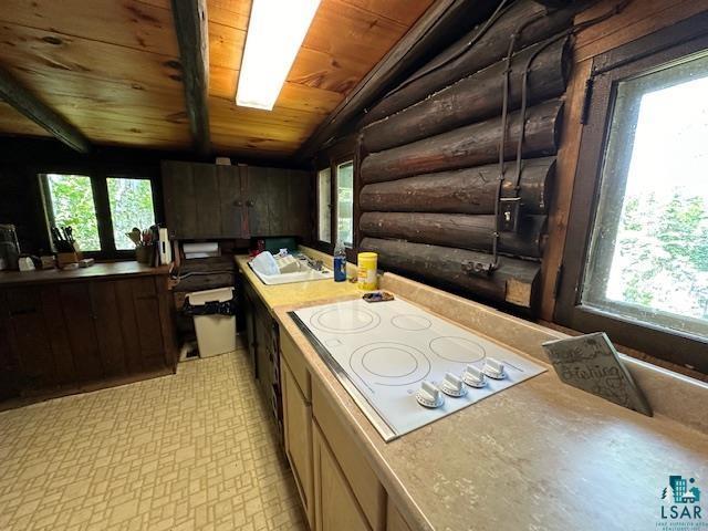 kitchen featuring log walls, white electric cooktop, lofted ceiling, and wooden ceiling
