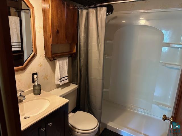 full bathroom with vanity, curtained shower, and toilet