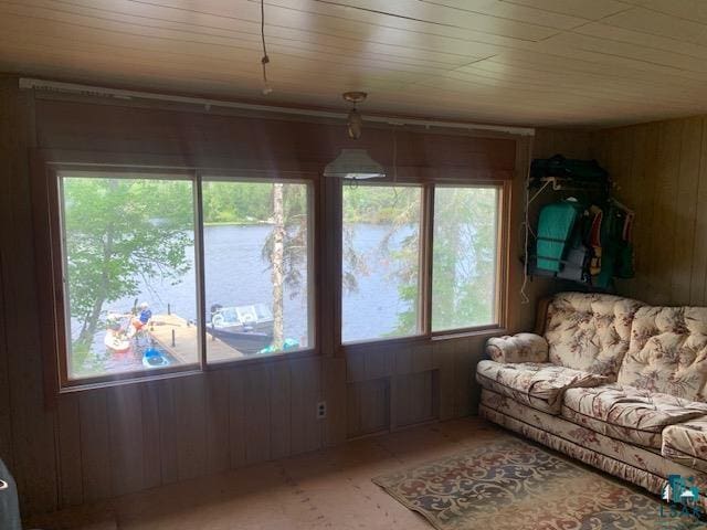 living room with wood walls and a water view