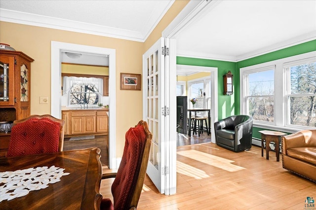 interior space with crown molding, french doors, and light wood-style floors