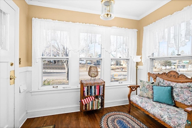 living area with crown molding, baseboards, and wood finished floors