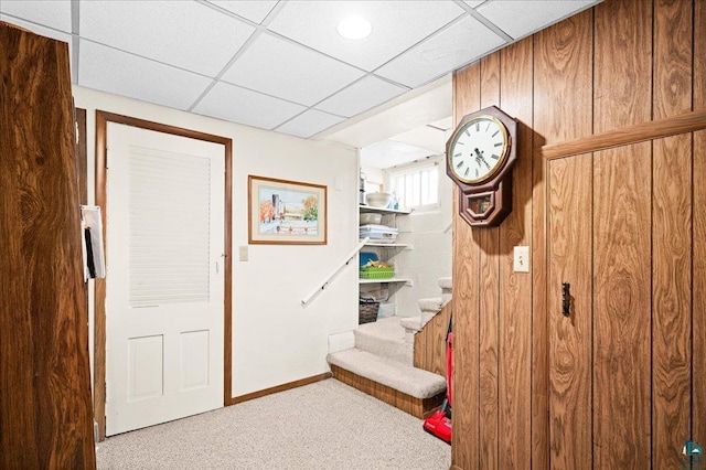 interior space with baseboards, carpet, and a drop ceiling