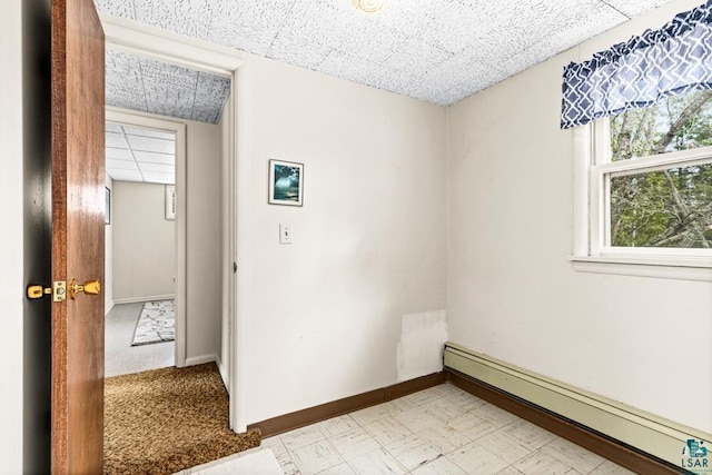 empty room featuring baseboards, light floors, and a baseboard radiator