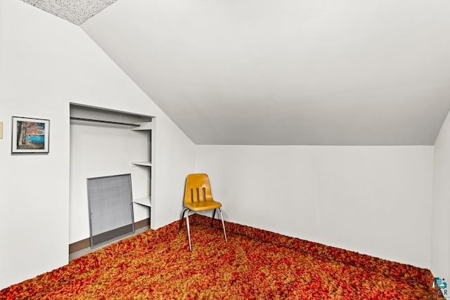 additional living space featuring vaulted ceiling and built in shelves