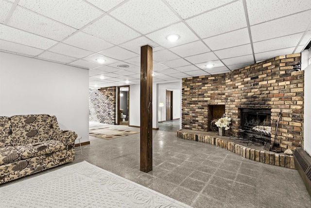 living room with a brick fireplace, recessed lighting, baseboards, and a paneled ceiling