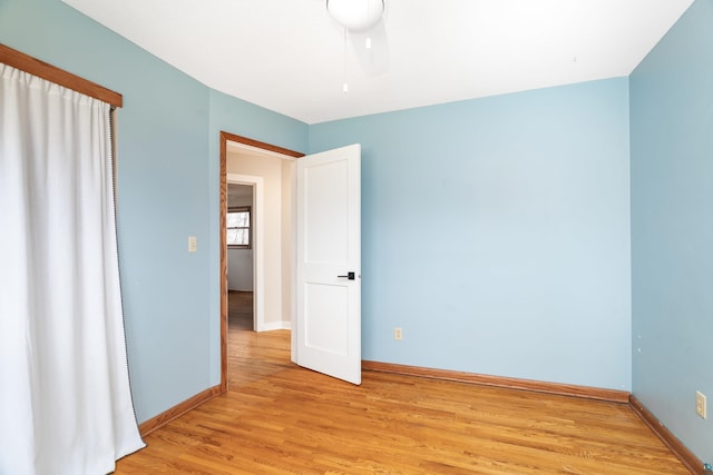 empty room with baseboards and light wood-style flooring