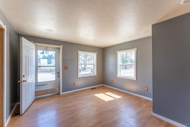25 4th Ave, Soudan, MN 55782 - interior space featuring baseboards, light wood finished floors, a textured ceiling, and visible vents