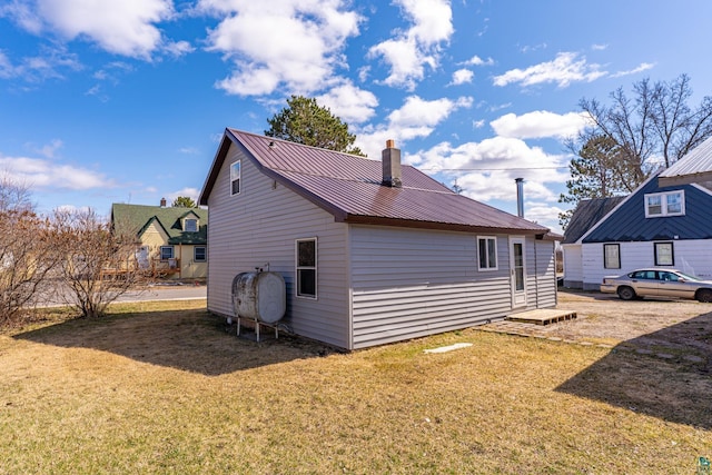 25 4th Ave, Soudan, MN 55782 - back of house with a lawn, metal roof, a chimney, and heating fuel