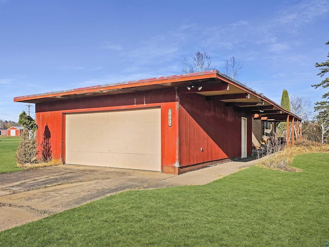 view of property exterior with a lawn, an outbuilding, concrete driveway, and a detached garage