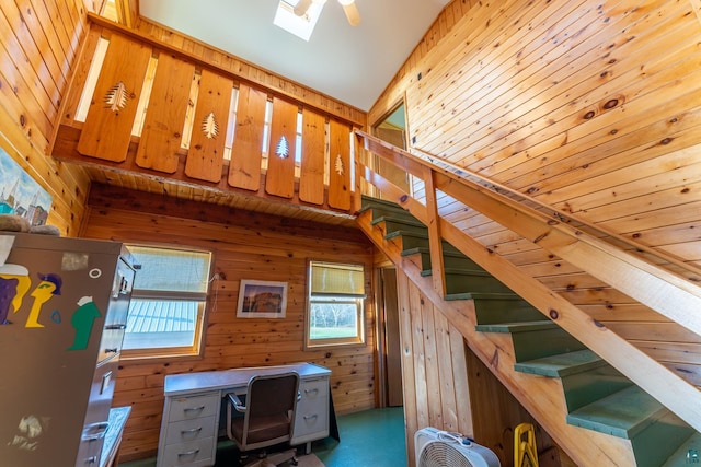 staircase featuring a skylight and wood walls