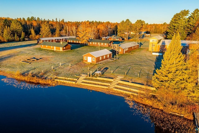 birds eye view of property featuring a water view and a wooded view