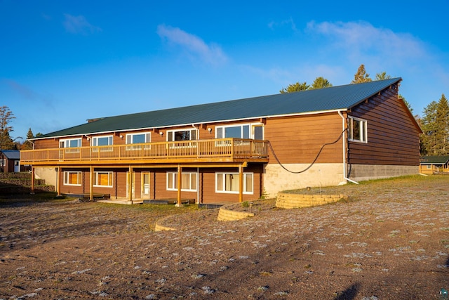 rear view of property featuring a deck and metal roof