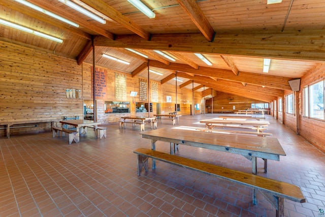 misc room featuring wooden walls, brick floor, high vaulted ceiling, beamed ceiling, and wood ceiling