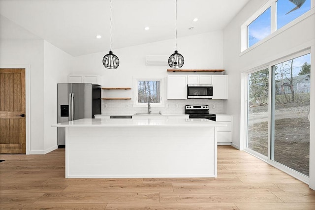 kitchen featuring light countertops, white cabinets, appliances with stainless steel finishes, and a kitchen island