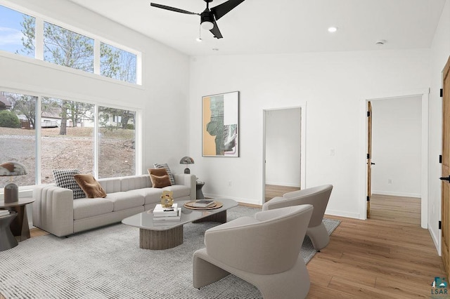living room with wood finished floors, baseboards, ceiling fan, high vaulted ceiling, and recessed lighting