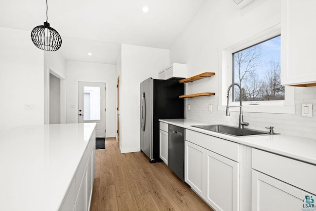 kitchen featuring a sink, light countertops, decorative backsplash, and stainless steel appliances
