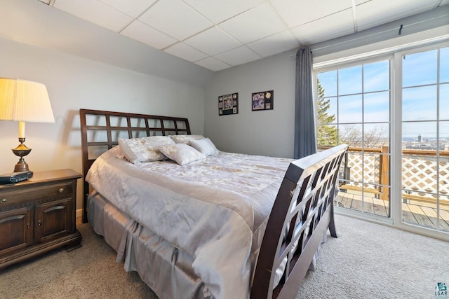 bedroom featuring a paneled ceiling and light carpet