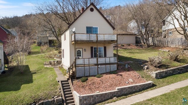 view of front of house with a balcony and a front yard