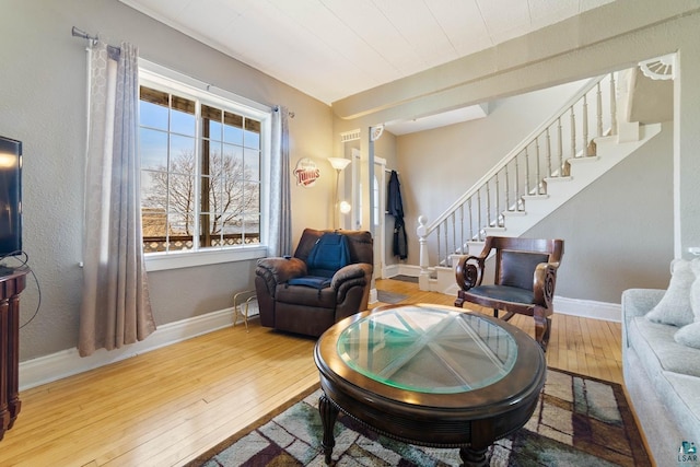 sitting room with baseboards, stairs, and hardwood / wood-style floors
