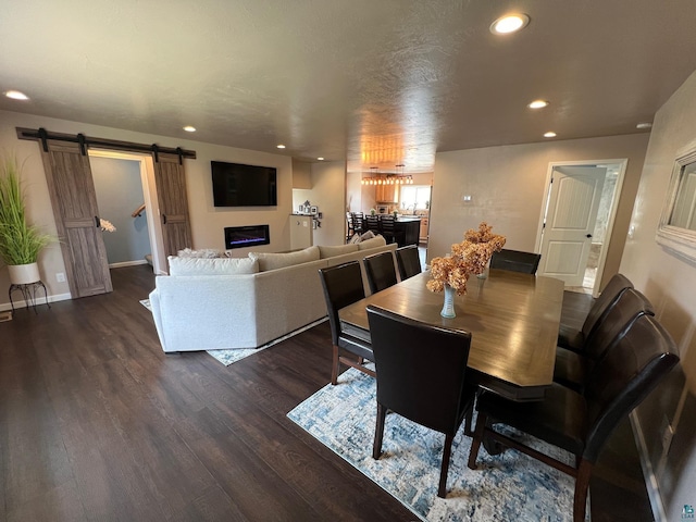 dining space featuring recessed lighting, baseboards, a barn door, and dark wood-type flooring