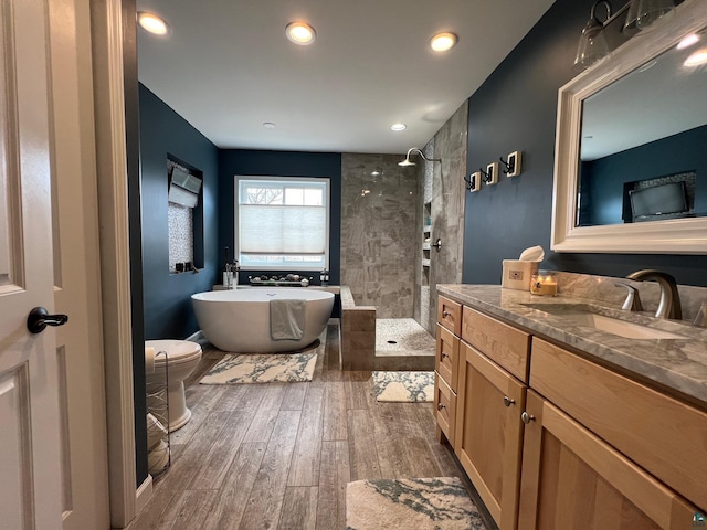 full bathroom with walk in shower, vanity, recessed lighting, a freestanding tub, and wood finished floors