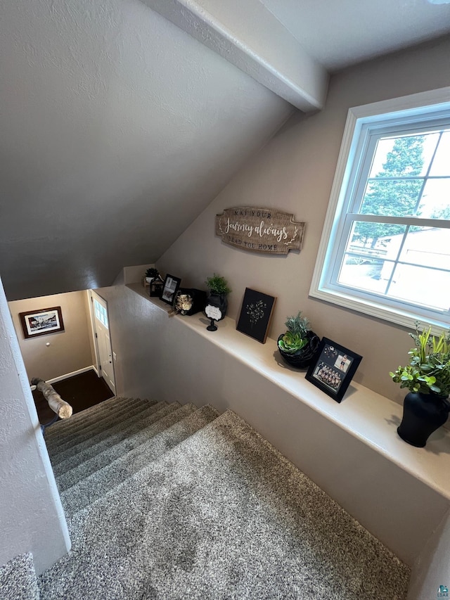 staircase featuring vaulted ceiling with beams and carpet flooring