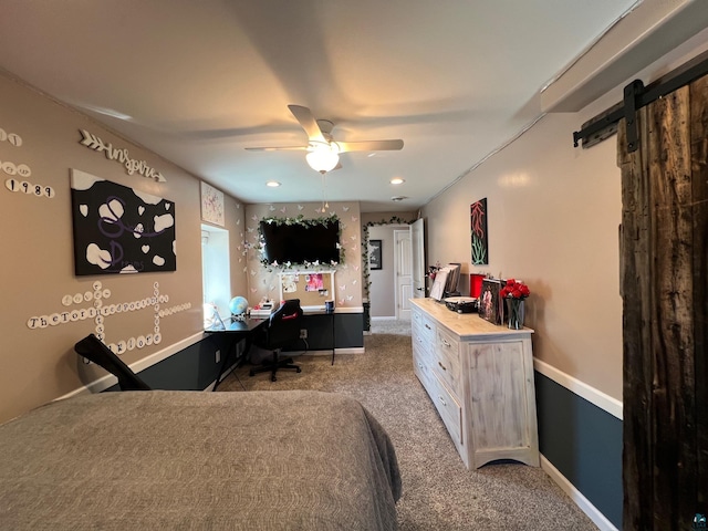 carpeted bedroom featuring ceiling fan, a barn door, and baseboards