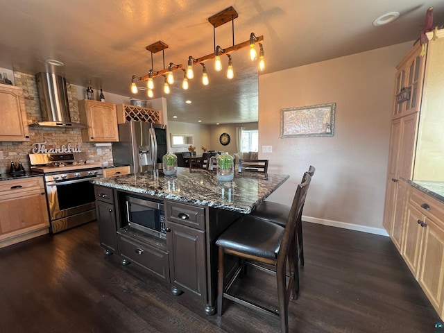kitchen with wall chimney range hood, a breakfast bar area, backsplash, dark wood-style flooring, and stainless steel appliances