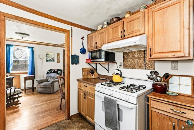 kitchen with tasteful backsplash, gas range gas stove, stainless steel microwave, ornamental molding, and under cabinet range hood