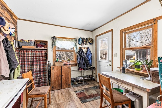 dining space with crown molding, wood finished floors, and a wealth of natural light
