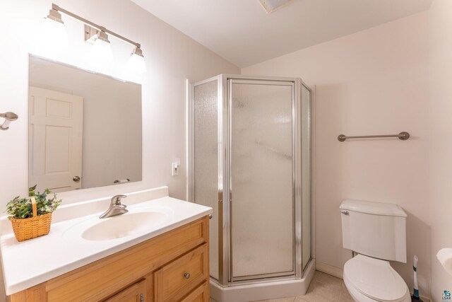 bathroom with vanity, tile patterned flooring, a stall shower, and toilet