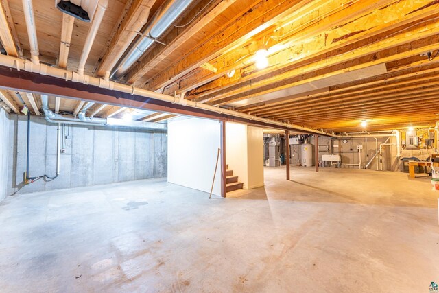 unfinished basement with a sink, gas water heater, and stairs