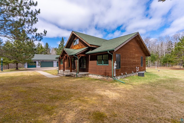 view of front of house with a porch, an outdoor structure, a front yard, and a detached garage