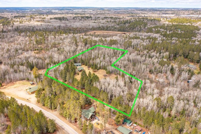 birds eye view of property featuring a wooded view
