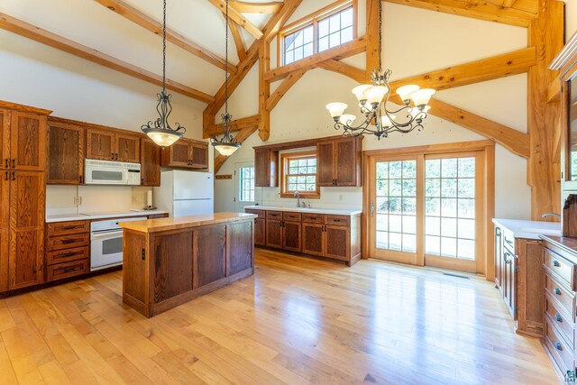 kitchen featuring a kitchen island, white appliances, beamed ceiling, high vaulted ceiling, and a sink