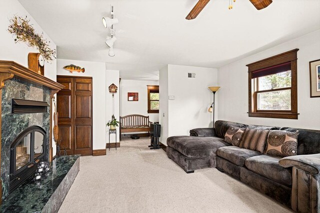 living area featuring visible vents, plenty of natural light, carpet, and ceiling fan